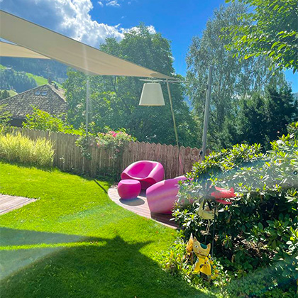 Garten mit zwei rosa Stühlen